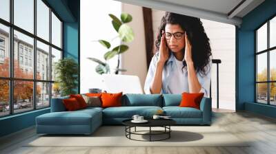 Exhausted african-american businesswoman having headache in office. Bored young african girl tired of learning sit at home looking at laptop,  apathetic black female university student frustrated  Wall mural