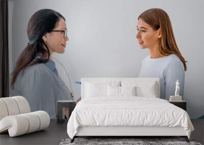 Female adult gynecologist working with patient in clinic Wall mural