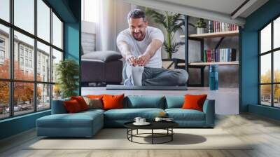 Handsome adult man doing fitness exercise at home Wall mural