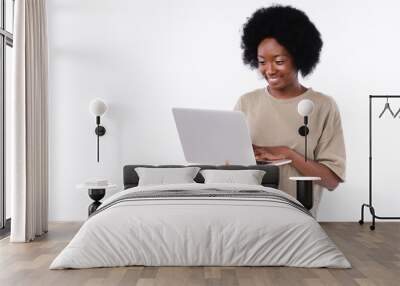 Happy afro teenage girl using laptop isolated over white background Wall mural