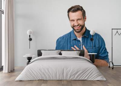 Happy young caucasian man in denim clothes laughing, touched with a compliment, good sense of humor isolated in white background Wall mural