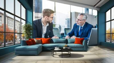 Horizontal shot of young executive showing his business proposal to a senior man sitting in foyer Wall mural