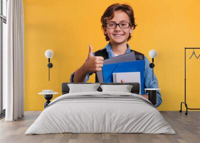 intelligent 10s caucasian boy in glasses and casual attire with books for studing at school isolated Wall mural