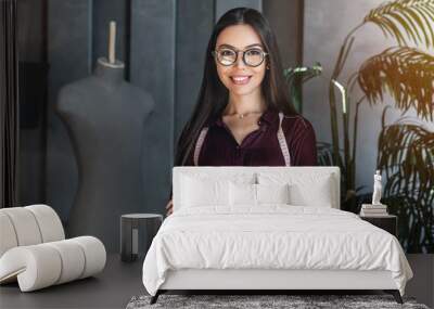 Portrait of young female fashion designer standing in design studio Wall mural