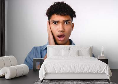 shocked young mixed-race man in casual attire isolated over white Wall mural