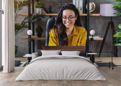 Young happy cute business woman sit indoors in home office using laptop computer Wall mural