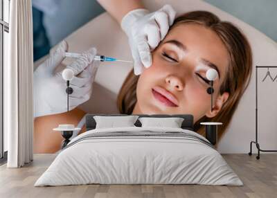 Young woman gets beauty facial injections in salon Wall mural