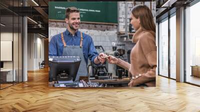 Young woman paying by credit card at cafe Wall mural