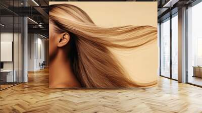 A woman with long hair is shown with her face turned away from the camera. The hair is flowing in the wind, giving the image a sense of movement and freedom. The woman's expression is calm and serene Wall mural