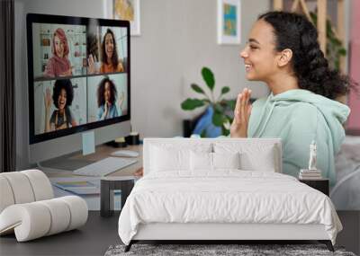 African american teen girl talking to happy multicultural diverse teenage friends during online virtual chat video call in group conference social distance chat virtual meeting using computer at home. Wall mural