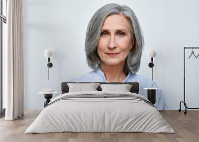 Confident beautiful mature business woman standing isolated on white background. Older senior businesswoman, 60s grey haired lady professional looking at camera, close up face headshot portrait. Wall mural