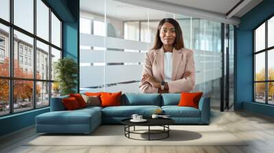 Confident proud young professional business woman ceo, female corporate executive leader, African American lady lawyer wearing suit standing arms crossed in office near glass wall, portrait. Wall mural