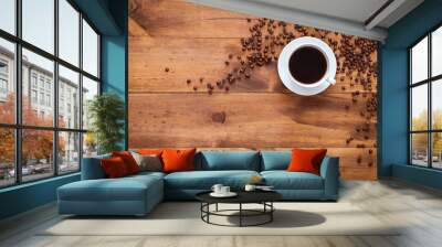 Cup of black morning coffee and cofee beans scattered on brown wooden table, espresso dark coffe aroma cafe shop background, warm hot beverage drink in mug, top view, flat lay, closeup copy space Wall mural