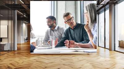 Diverse business people partners group negotiating at boardroom meeting.Multiethnic executive team discussing financial partnership agreement project strategy brainstorming sitting at table in office. Wall mural