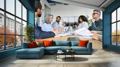 Diverse professional executive business team people discuss project sitting at meeting table in board room. Multiethnic company managers brainstorm financial plan working together in boardroom. Wall mural