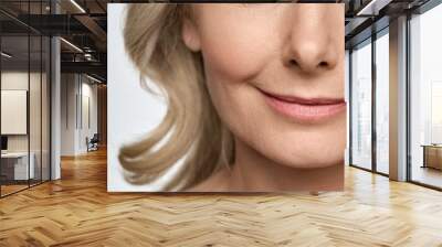 Face close up portrait of happy smiling mid age 50 years old woman isolated on white background. Advertising of facial skin care anti wrinkle tightening lift products for women in menopause. Wall mural