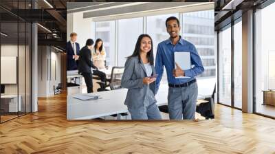 Happy confident international business team people two Indian and African American coworkers executive leaders standing in office. Smiling diverse workers in meeting room, corporate portrait. Wall mural