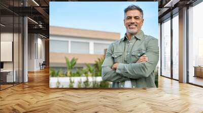 Happy mature older Latin man new property buyer modern villa owner or realtor salesman standing outside home, smiling middle aged homeowner posing outdoor near country house. Portrait. Wall mural