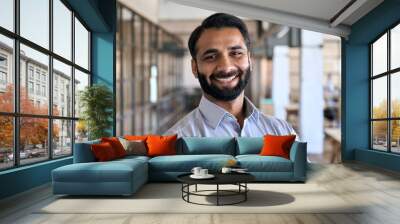 Happy smiling bearded indian business man small business owner, company leader or sales manager, male hispanic ceo executive, successful lawyer looking at camera standing in office, headshot portrait. Wall mural