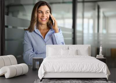 Happy smiling mature middle aged business woman, older professional lady executive manager leader talking on phone making business call on cellphone at work communicating by telephone in office. Wall mural