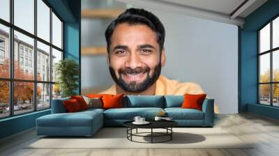 Happy smiling positive handsome wealthy bearded 30s indian ethnic man looking at camera feeling cheerful, relaxed and satisfied at home indoors. Close up front male face portrait. Wall mural