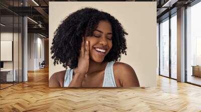 Happy young adult African American woman beauty female model, pretty 20s Black lady with curly hair beautiful face advertising skin care products isolated at beige background. Aesthetic authentic shot Wall mural