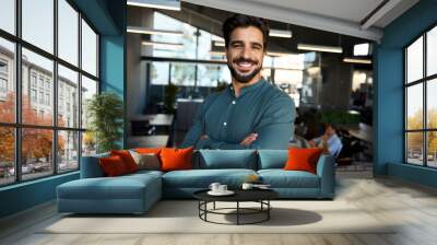 Happy young Latin professional business man looking at camera at work, portrait. Confident smiling bearded businessman, male entrepreneur, company worker or director standing in coworking office. Wall mural