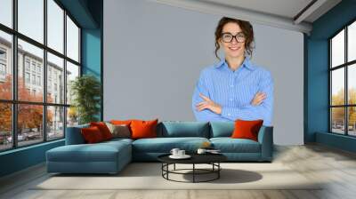 Happy young smiling confident professional business woman wearing blue shirt and glasses, happy pretty female executive looking at camera, standing arms crossed isolated at gray background, portrait. Wall mural