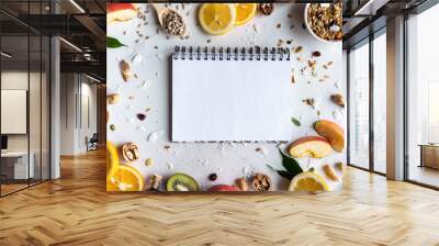 Healthy food nutrition concept, fresh summer fruits nuts granola seeds and empty blank notebook on white background, organic super food on table, detox diet for health care, top view, copy space Wall mural