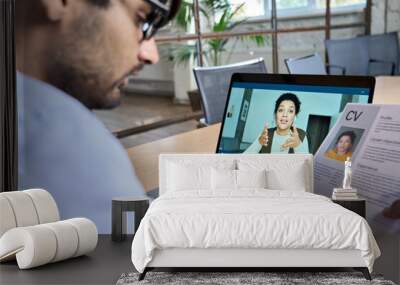 Indian human resource manager holding cv having virtual job interview conversation with remote female candidate during distant business video call on laptop computer. Online recruitment concept. Wall mural