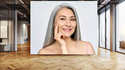 Mature beautiful smiling middle aged asian woman, senior older grey haired lady looking at camera Advertising of under eye care antiage anti wrinkle skin care, isolated on white headshot. Wall mural