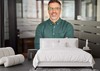 Portrait of smiling professional mature business man, happy businessman ceo of middle age, mid adult entrepreneur or executive manager in his 50s wearing glasses and green shirt standing in office. Wall mural