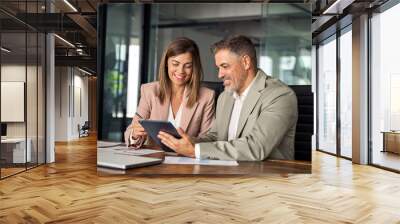 Professional business executives office team working using digital tablet fintech computer sitting at table. Two mid aged colleagues managers discussing financial corporate plan at corporate meeting. Wall mural