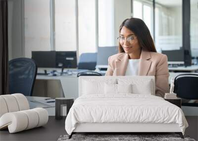 Professional business woman employee working on computer in office. Young busy African American female company finance manager executive using laptop managing financial project sitting at desk. Wall mural