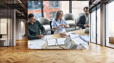 Professional executive businesspeople discuss corporation project planning sit at meeting table in boardroom. Company managers brainstorm financial plan working together with document papers in office Wall mural