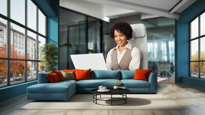 Professional happy business woman employee working on computer in office. Young busy African American businesswoman female company executive using laptop managing financial project sitting at desk. Wall mural