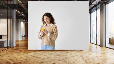 Smiling pretty curly young woman model using mobile phone, happy girl holding smartphone browsing internet on cellphone technology device standing isolated on white background, copy space. Wall mural