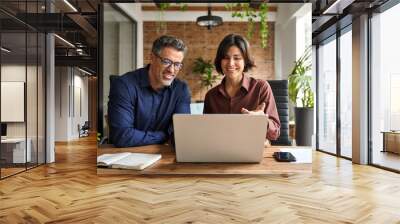 Two busy happy professional business man and woman executive leaders team using laptop working on computer at work desk having conversation on financial project at meeting in office. Wall mural