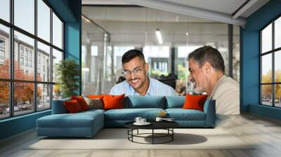 Two busy happy professional business people men executive team, male partners working using laptop, manager consulting worker talking managing online finance data in office sitting at desk. Vertical. Wall mural