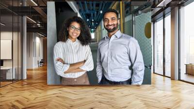 Two happy diverse professional executive business team people African American woman and Indian man looking at camera standing in office lobby hall. Multicultural company managers team portrait. Wall mural