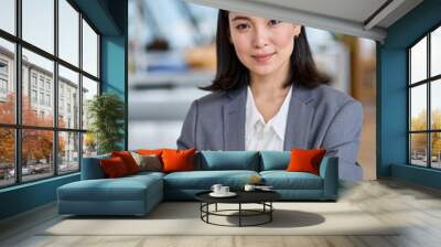 Young confident Asian business woman entrepreneur, elegant professional company manager, successful businesswoman executive leader wearing suit standing in office with arms crossed. Vertical portrait Wall mural