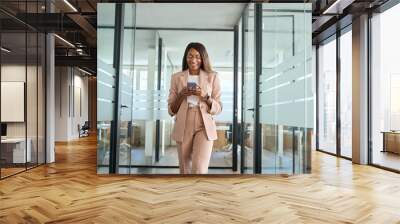 Young happy elegant busy professional African American business woman company executive manager worker wearing suit using cell phone walking in office hall holding mobile phone and working. Wall mural