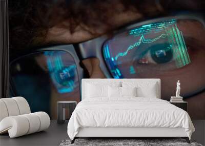 Young indian business man trader wearing glasses looking at computer screen with trading charts reflecting in eyeglasses watching stock trading market financial data growth concept, close up. Wall mural