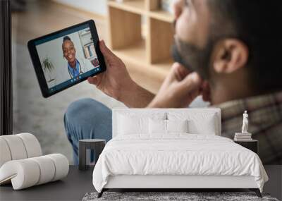 Young indian latin bearded businessman having videocall meeting at home with black female doctor therapist using tablet computer pointing to throat. Online virtual telemedicine health care concept. Wall mural