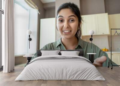 Young indian woman speaking to webcam during conference video call working at home office. Distance teacher or tutor teaching online, giving workshop webinar. Videocall screenshot closeup headshot. Wall mural