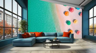 Aerial view of colorful beach umbrellas on a pristine sandy beach, with clear turquoise waters creating a perfect summer vibe. Wall mural