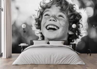 A Freckled Boy Laughs with Eyes Closed and Curly Hair Wall mural