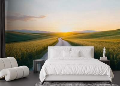 Bright sunrise illuminating a winding dirt road through a vast countryside landscape symbolizing the start of a new path and journey of and adventure Wall mural