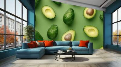 Close up of ripe avocado sliced in half surrounded by symbols representing healthy fats nutrients and a clean eating lifestyle  Green minimalist background with copy space for text Wall mural