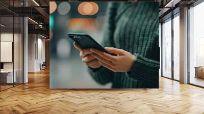 Close up shot of a person s hand holding a mobile phone or smartphone with a blurred background showcasing the use of a mobile wallet and secure digital payment transactions Wall mural